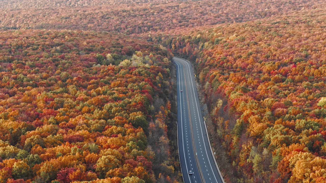 山上的公路在清晨，在日落之后，在五彩缤纷的秋天季节。空中无人机视频与平移摄像机运动。