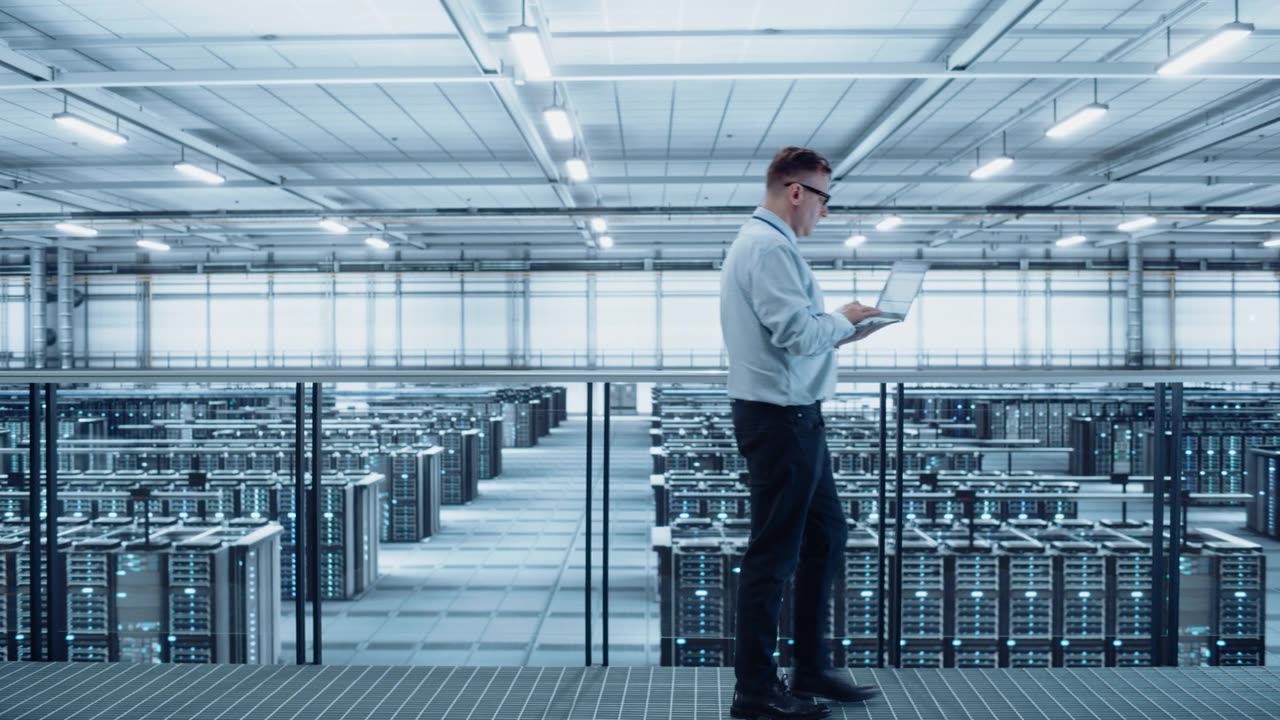 详情图-数据中心工程师使用笔记本电脑。服务器农场云计算专家设施与成年男性系统管理员与数据保护网络为网络安全工作。