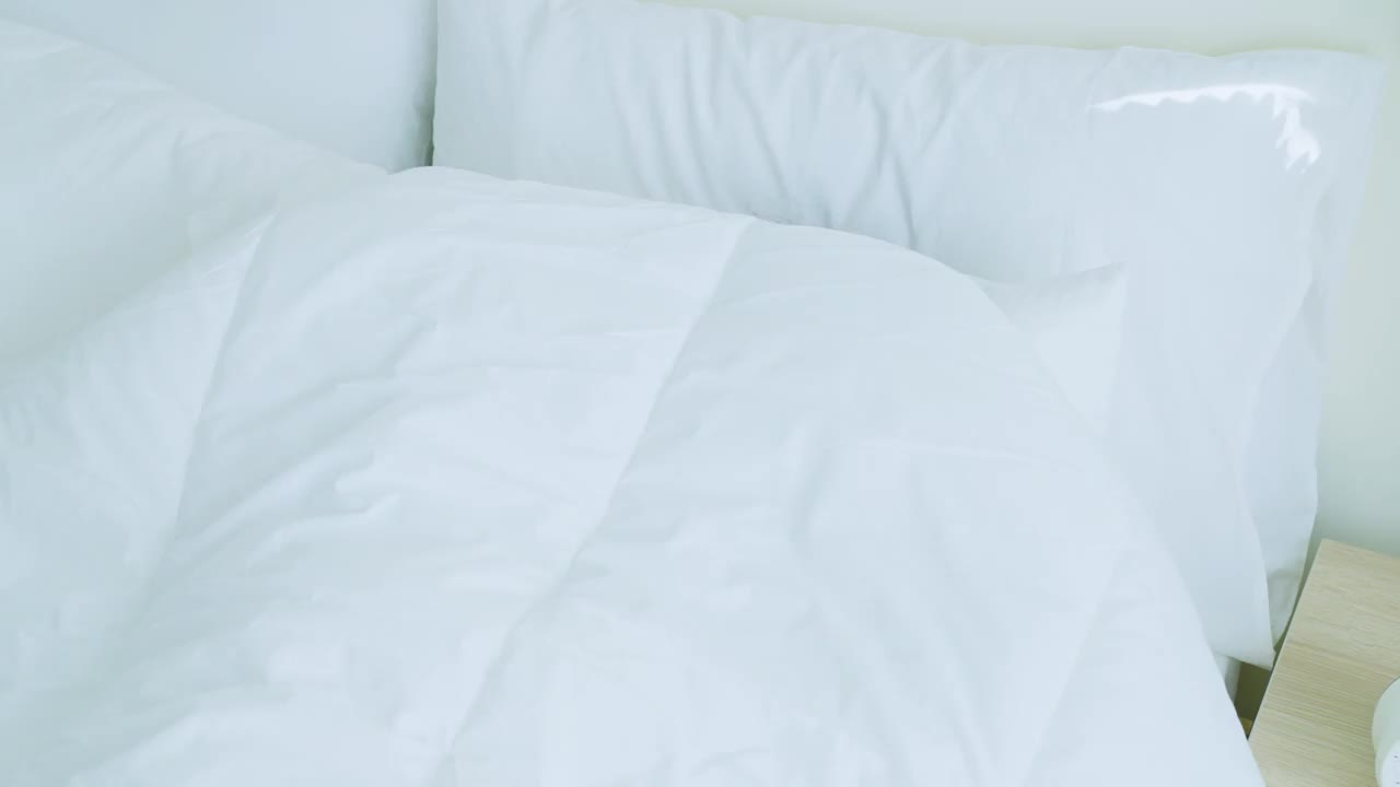 亚洲美丽的女孩穿着睡衣躺在床上感到恶心。迷人的睡眠年轻女子触摸额头，感觉不好的发烧和头痛后在床上醒来在家里早上。