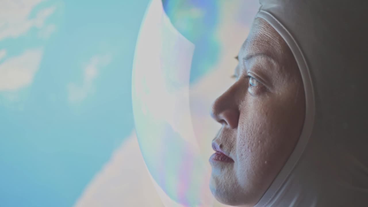 亚洲华裔女宇航员从太空飞船上透过窗户看地球