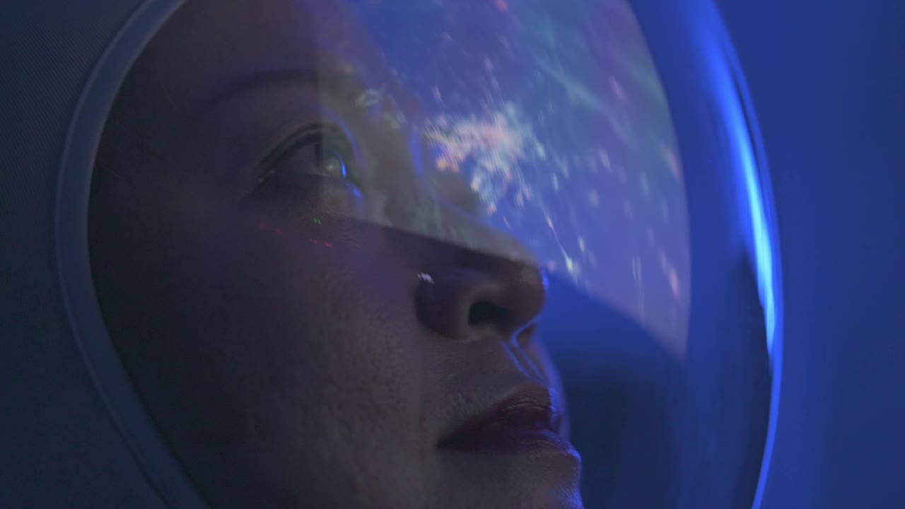 亚洲华裔女宇航员从太空飞船上透过窗户看地球