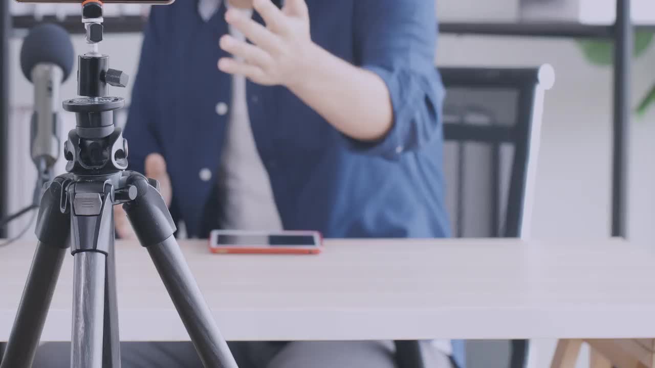 两个年轻人，一男一女，在录音棚里互相聊天并录制播客。4 k决议。