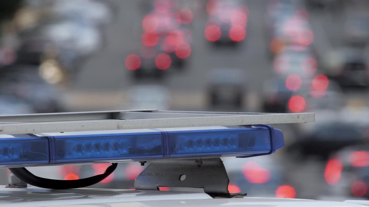 救护车灯在道路上的紧急车辆城市高速公路交通车辆高速公路繁忙的街道。蓝灯闪烁散景背景交通。警笛警车在大城市街道交通堵塞