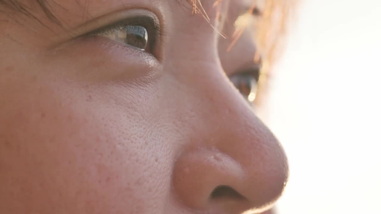 靠近亚洲华人中年成年女性的眼睛在早晨在家锻炼后背光室外看向别处