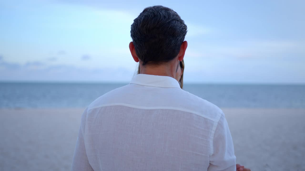 美丽的女人和可爱的男人在海滩上拥抱庆祝他们的订婚