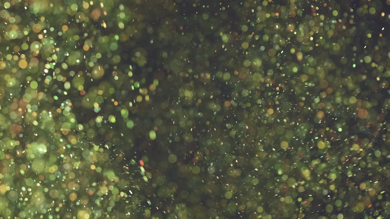 精灵粒子落在黑色背景上。慢动作