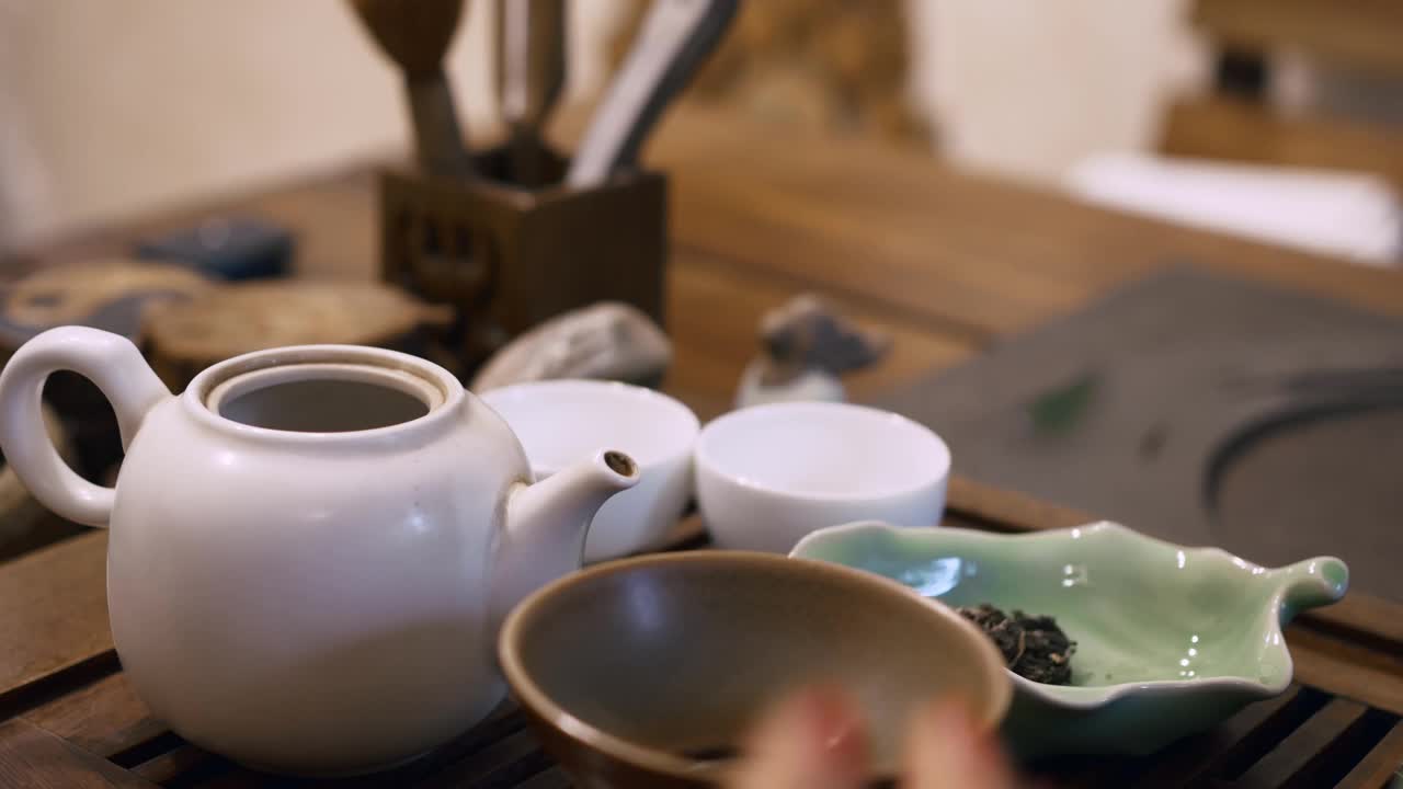 中国的泡茶仪式，一个红指甲的女人把干绿茶倒进茶壶里，用沸水冲泡。Cerimonium喝茶