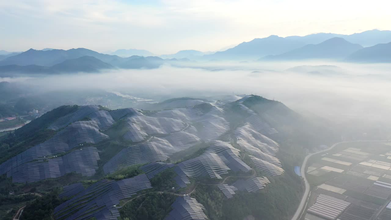 从山顶的晨雾中鸟瞰壮丽的太阳能发电站