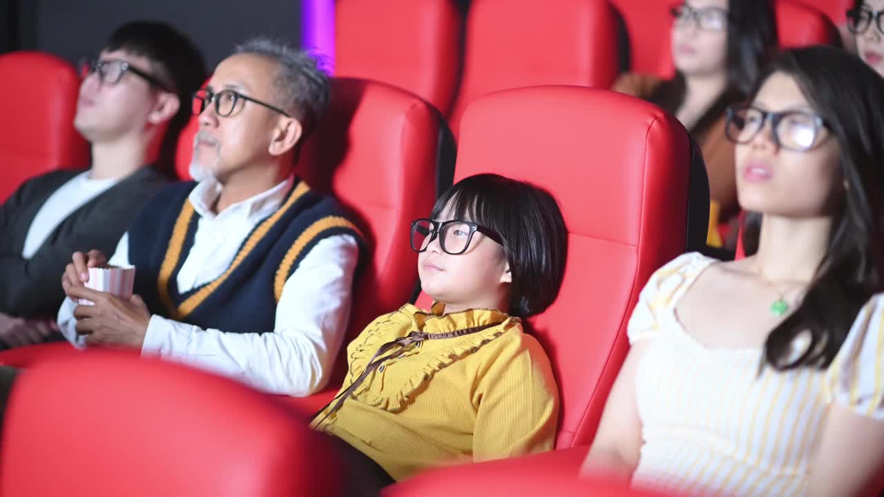 一群中国观众带着3D眼镜在电影院观看3D电影