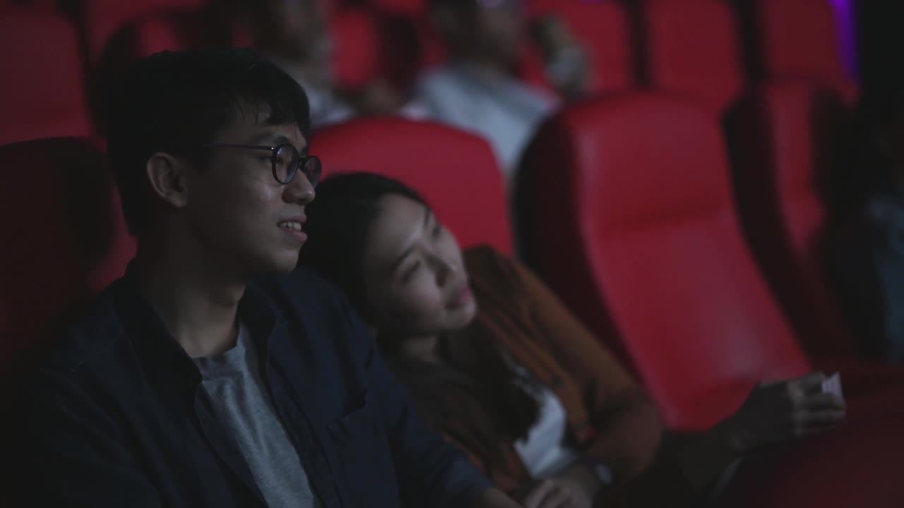 亚洲华人年轻夫妇喜欢在电影院看电影