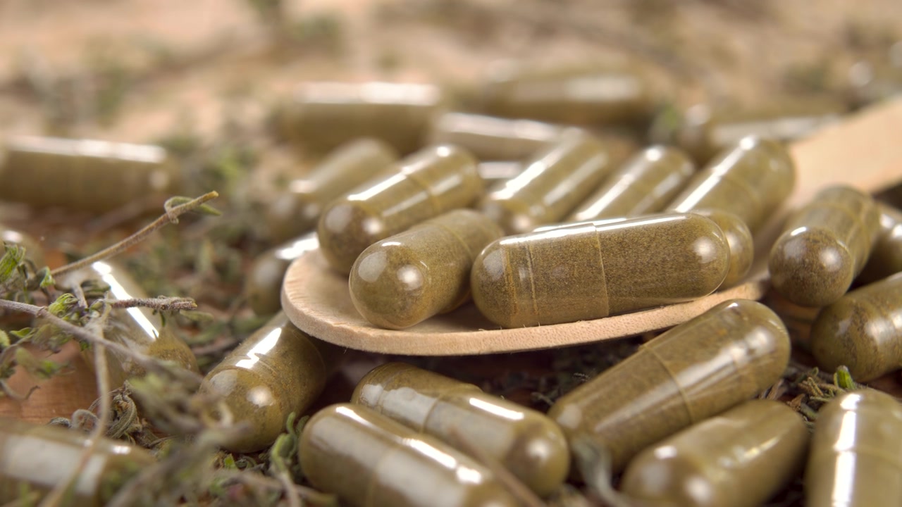 詳情圖-用木勺裝在木面上的藥用膠囊