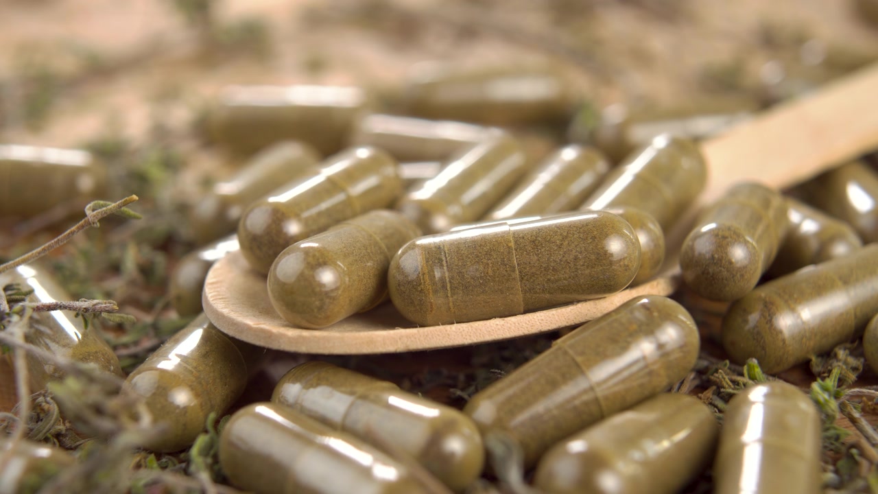 詳情圖-用木勺裝在木面上的藥用膠囊