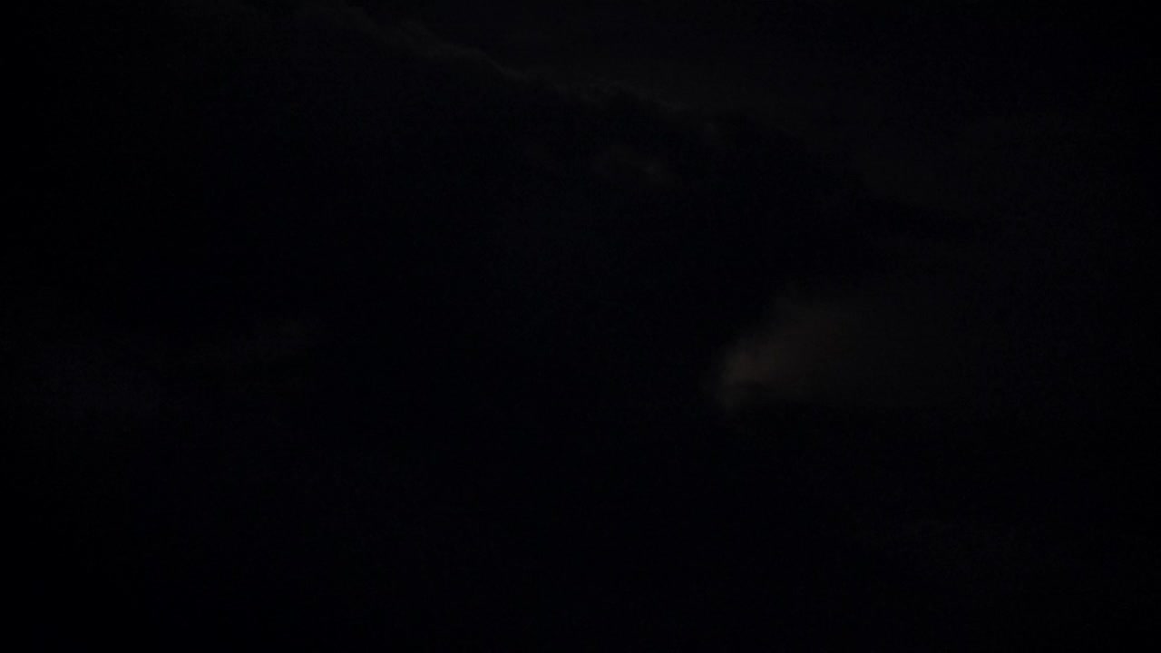 晚上的月亮又圆又黑。月光。月亮在黑暗的天空中移动。在傍晚或夜晚，黄色的满月从云层中掠过。神秘的仙境场景。自然背景