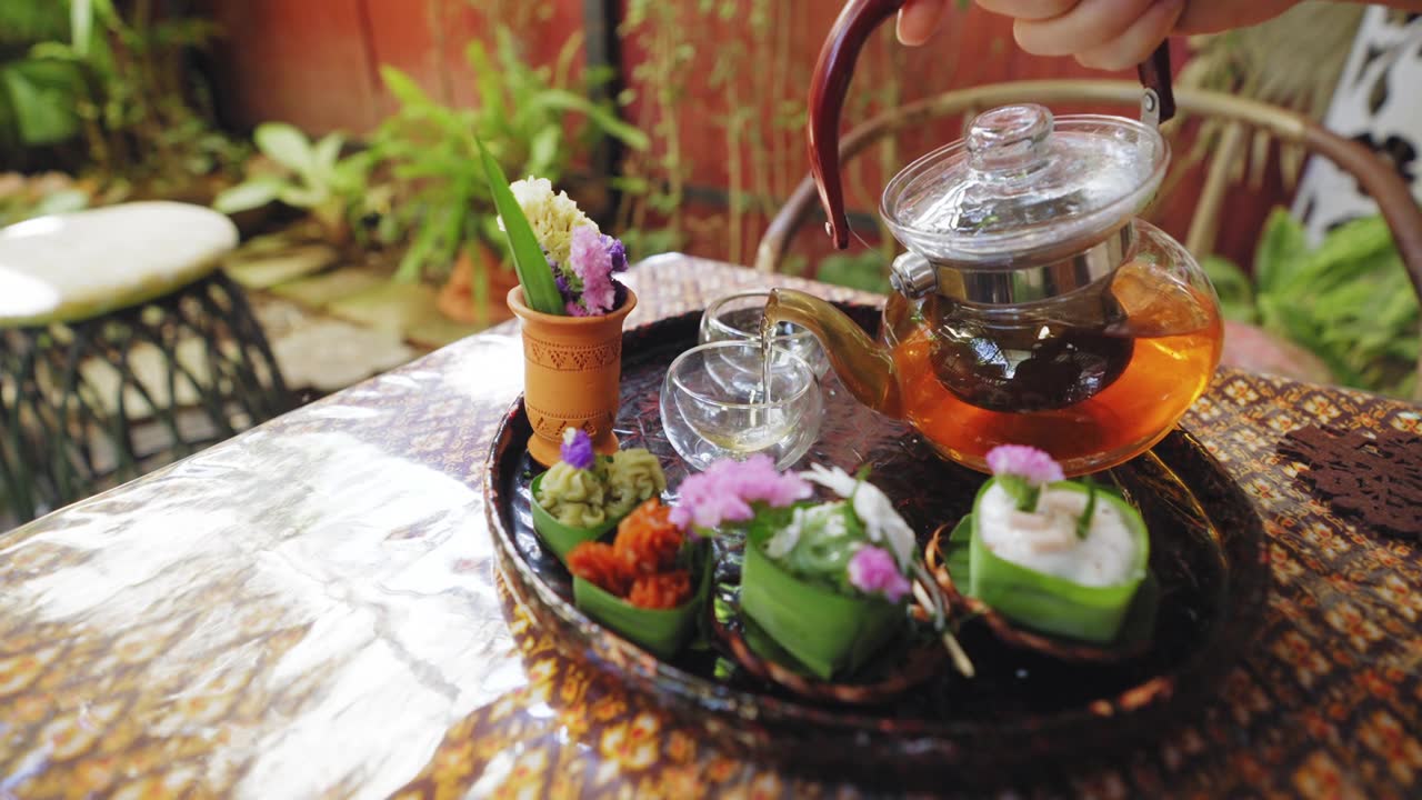 詳情圖-透明茶杯中的花草茶，搭配Khanom,Tako，泰式椰子布丁，Khanom,Chan，泰式分層甜點(diǎn)，