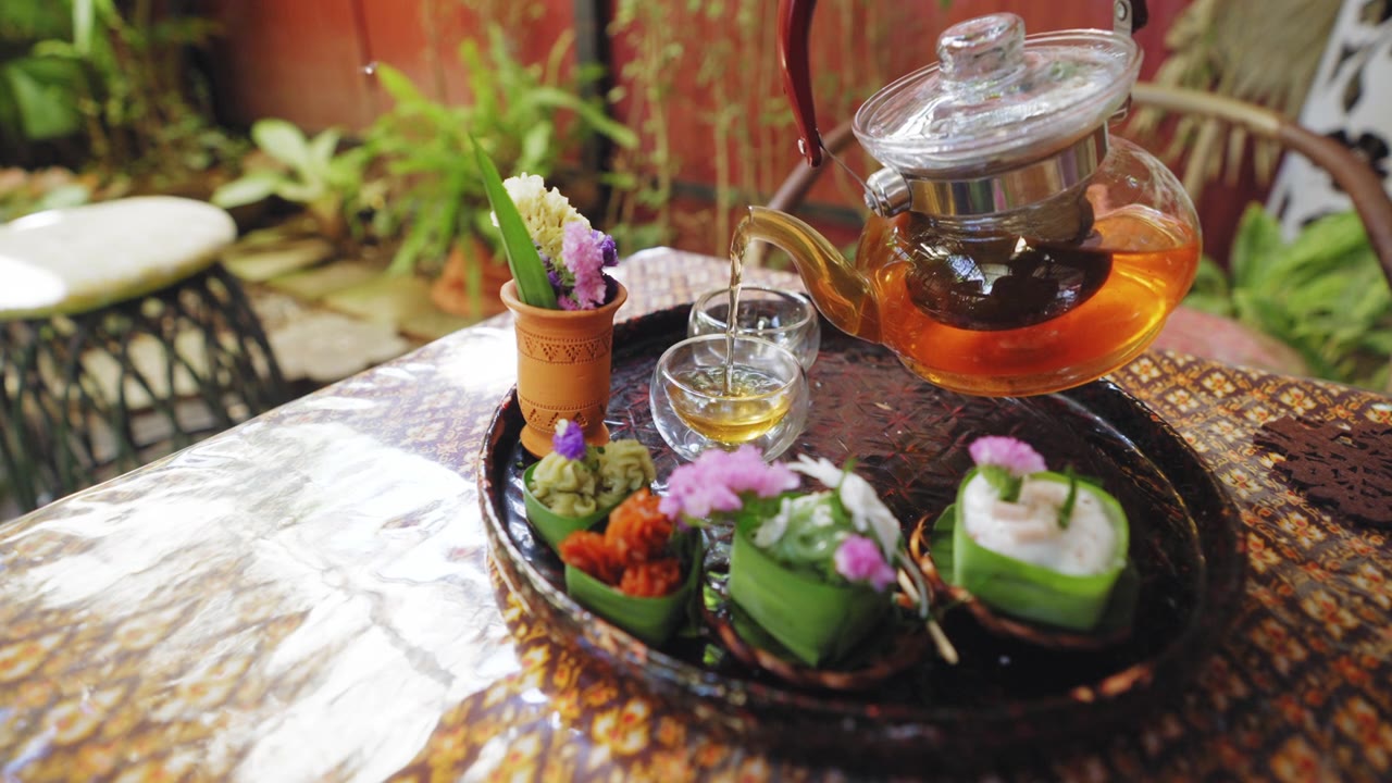 詳情圖-透明茶杯中的花草茶，搭配Khanom,Tako，泰式椰子布丁，Khanom,Chan，泰式分層甜點(diǎn)，