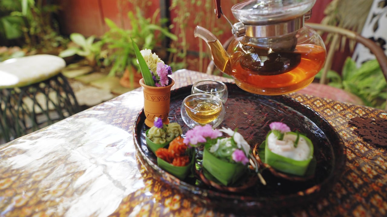 詳情圖-透明茶杯中的花草茶，搭配Khanom,Tako，泰式椰子布丁，Khanom,Chan，泰式分層甜點(diǎn)，