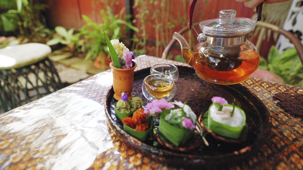 詳情圖-透明茶杯中的花草茶，搭配Khanom,Tako，泰式椰子布丁，Khanom,Chan，泰式分層甜點(diǎn)，