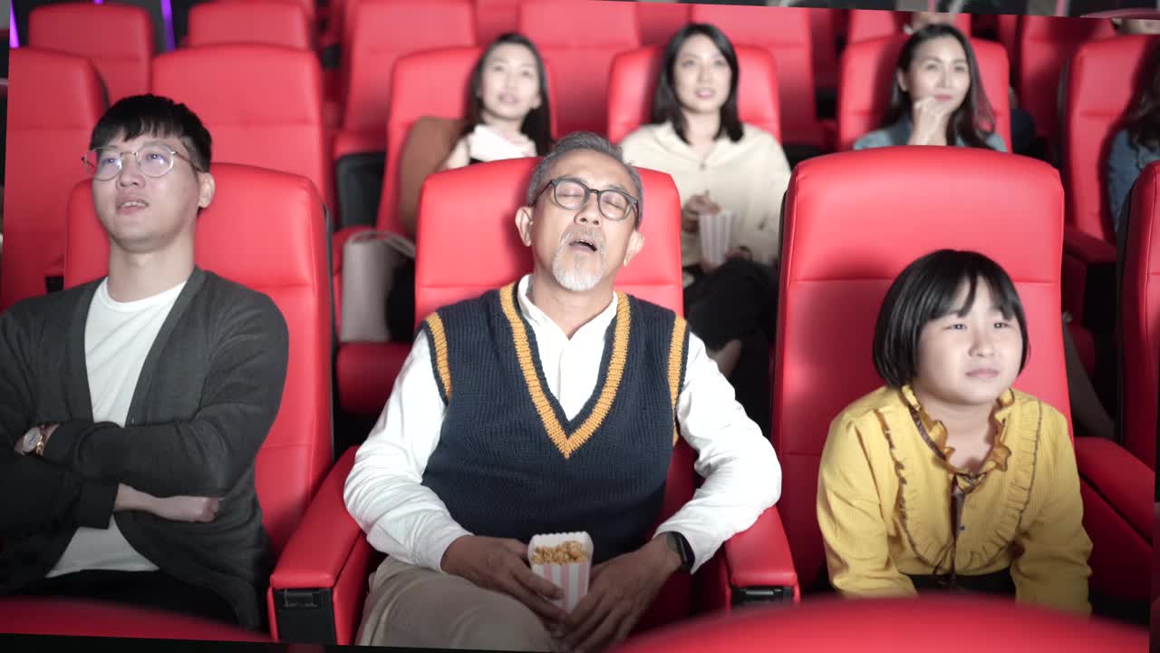 亚洲华人老人和孙女在电影院看电影睡着了