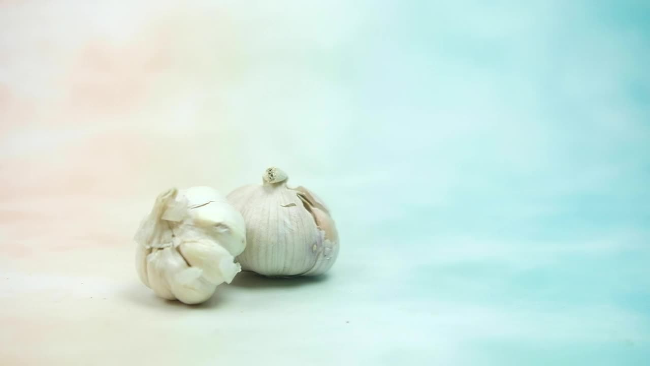 用慢动作将新鲜的大蒜滚入锅中。特写镜头。