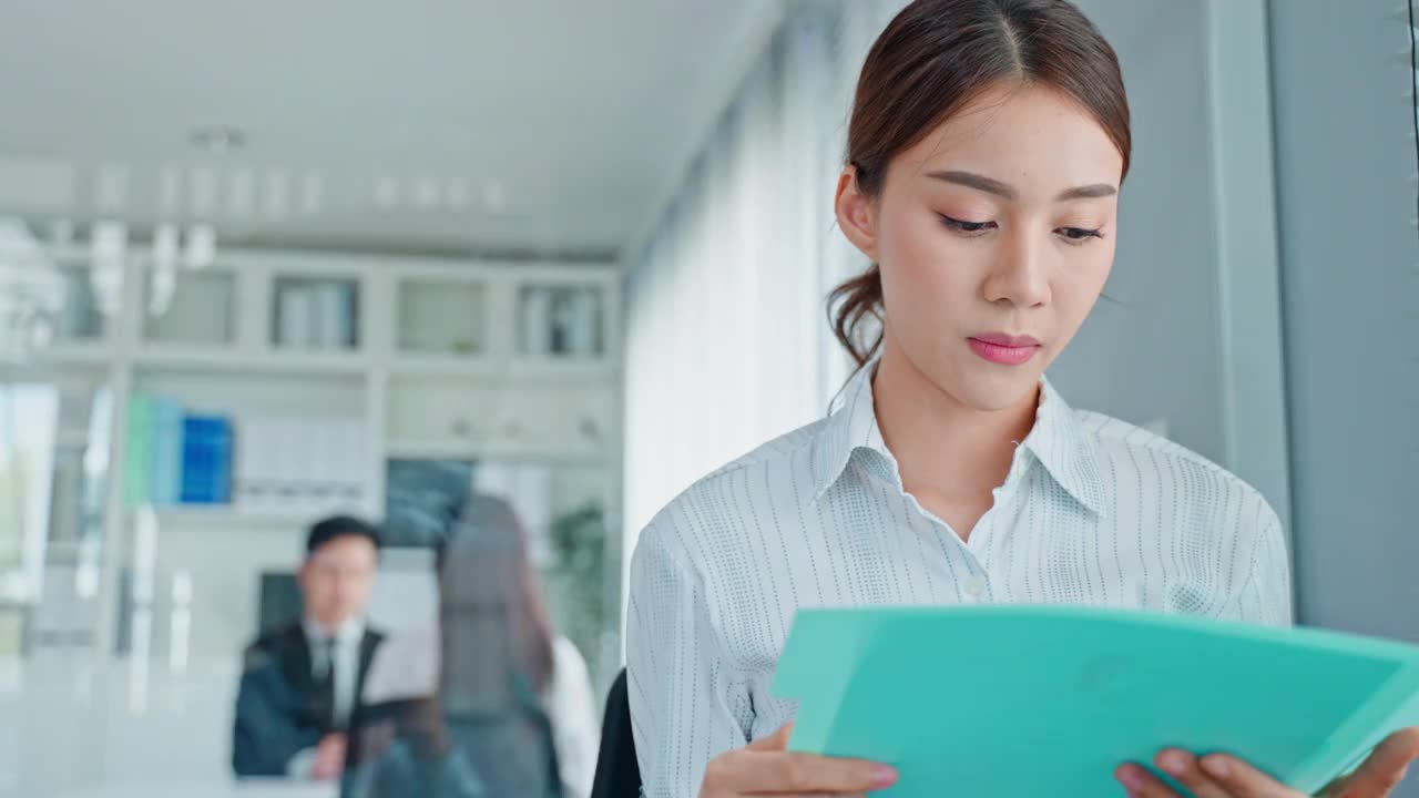 亚洲美女求职者准备在公司面试。有魅力的女性坐在整齐的椅子上，和人事经理紧张地等待申请工作，练习用简历说话