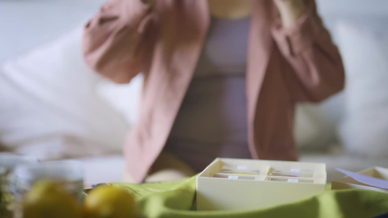 亚洲中国女子在客厅用智能手机拍摄朋友送的月饼礼盒
