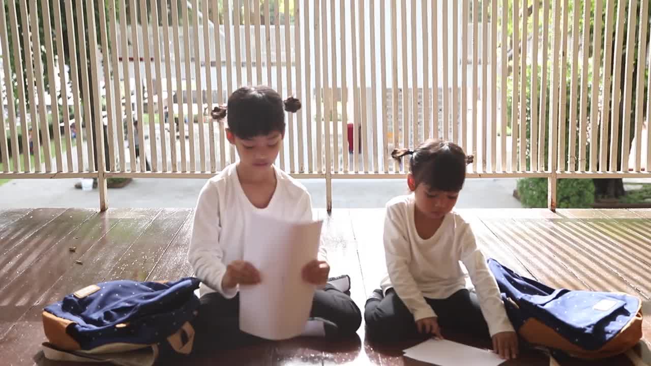 第一天上学的亚洲女孩正在收拾书包准备上学。幼儿园的女儿第一次上学很兴奋