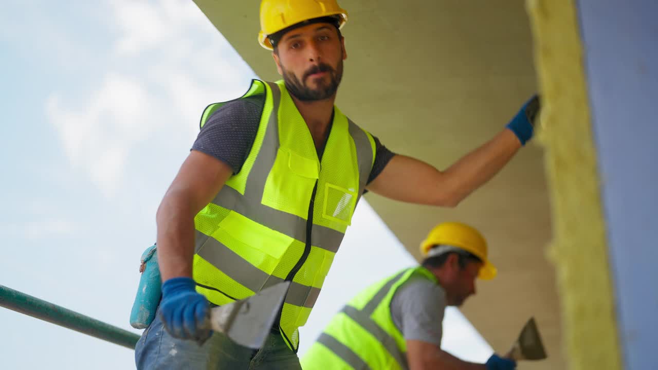 建筑工人在建筑外立面涂石膏