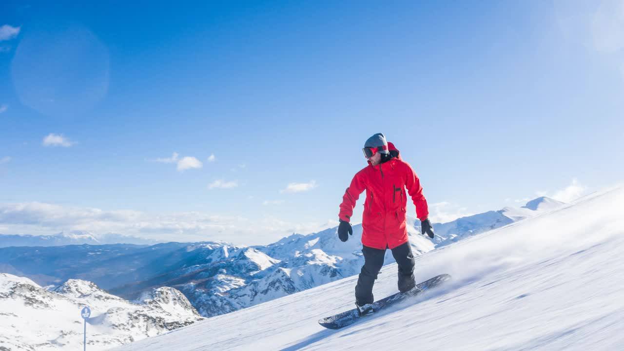 滑雪者享受阳光明媚的冬日，表演跳跃特技和雪水从滑雪坡上滑下来