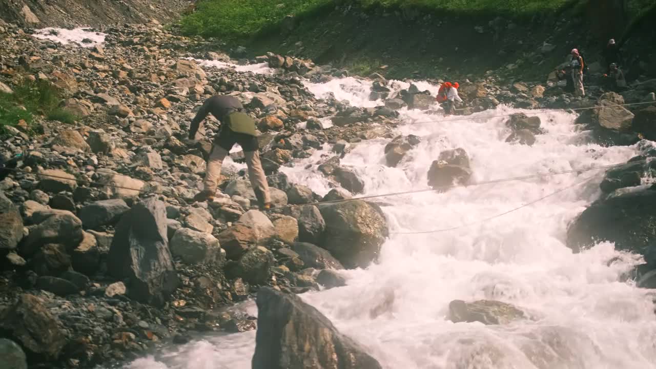 一个人用绳索渡过一条湍急的山河