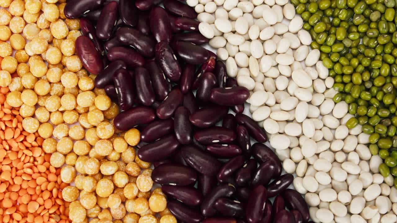 白豆、红豆、鹰嘴豆、绿豆和小扁豆的旋转条纹特写。在摄影棚拍摄扁豆和其他谷物。芸豆，种子的宏观镜头。食品烹饪视频