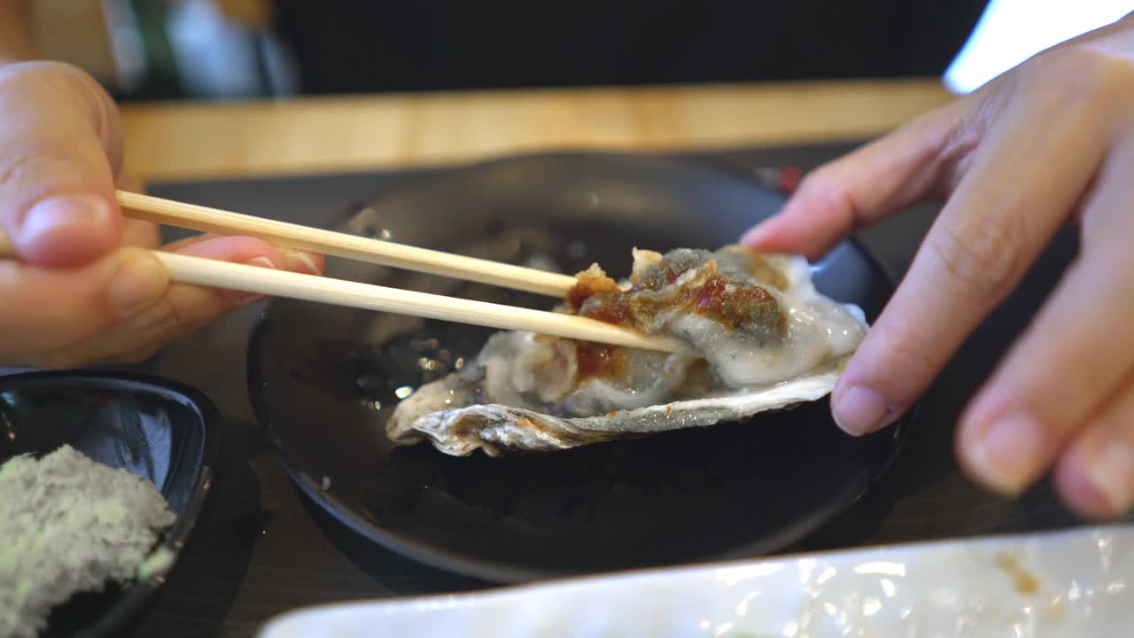 一位女士在日本餐厅吃新鲜的牡蛎