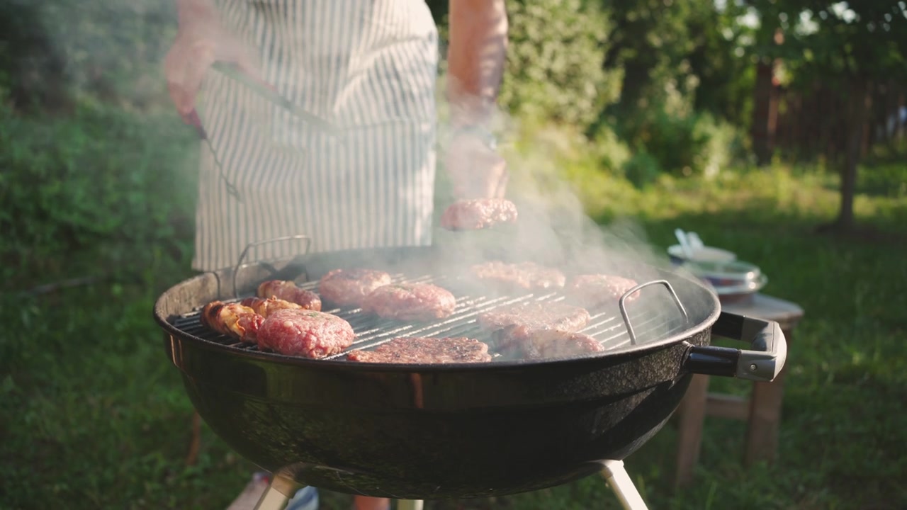 詳情圖-一個(gè)陌生的男人在燒烤架上翻動著牛肉