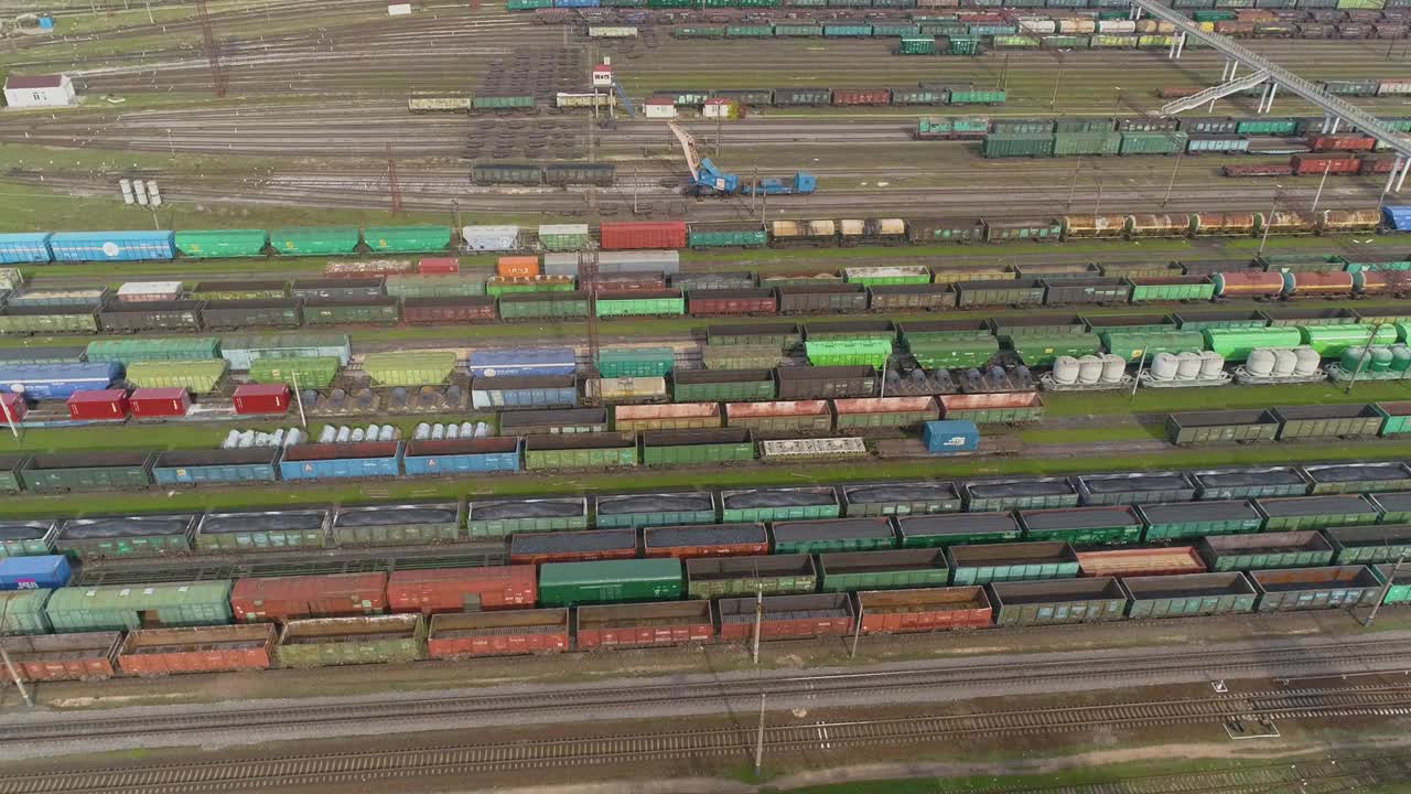 在火车站上空飞行。火车站的货运列车。大型工业铁路车辆段俯视图。