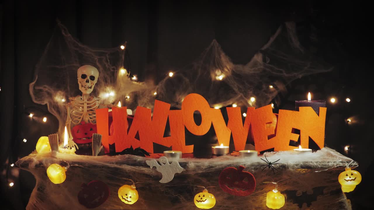 万圣节的南瓜和装饰品在晚上对抗可怕的黑暗墙壁与蜘蛛网。万圣节的问候。庆祝万圣节派对。南瓜脸、蜘蛛、蝙蝠和灯光下的骷髅