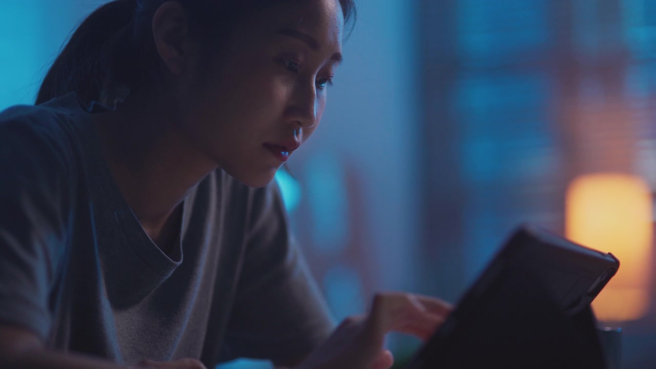 详情图-年轻的亚洲女性晚上用数码平板电脑看网络电视