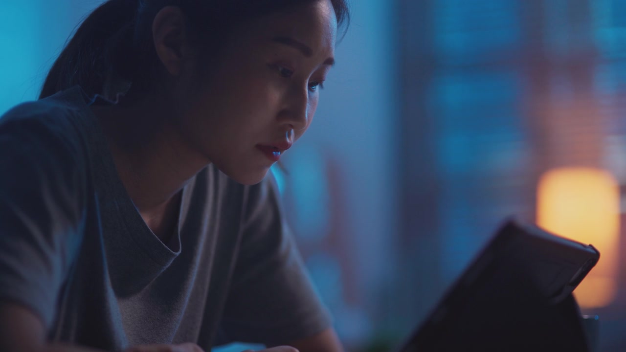 详情图-年轻的亚洲女性晚上用数码平板电脑看网络电视