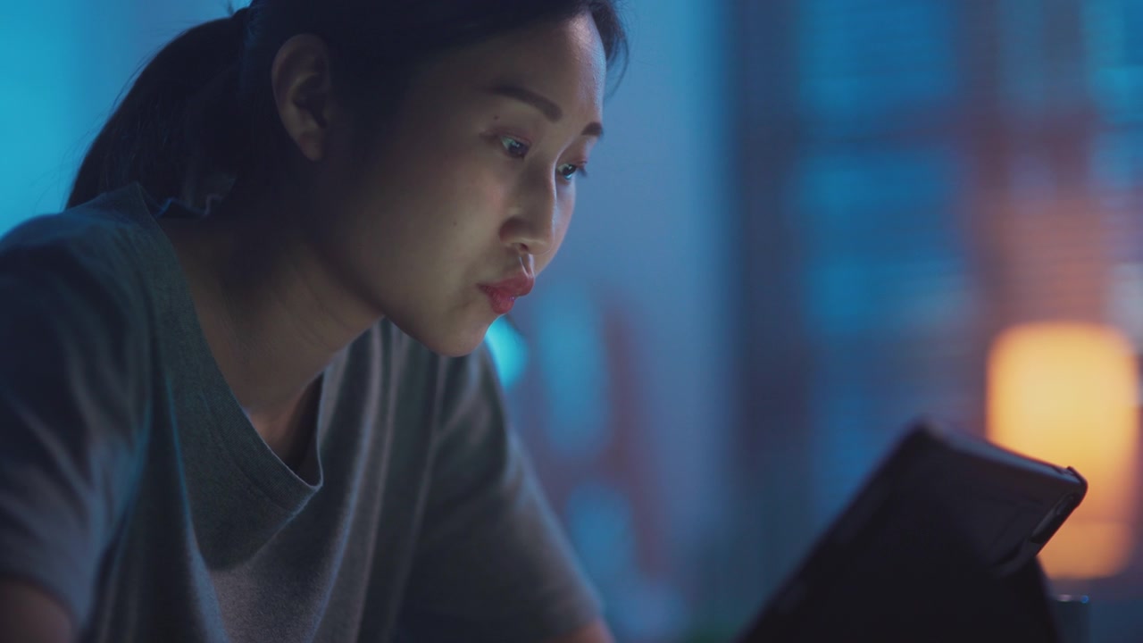详情图-年轻的亚洲女性晚上用数码平板电脑看网络电视