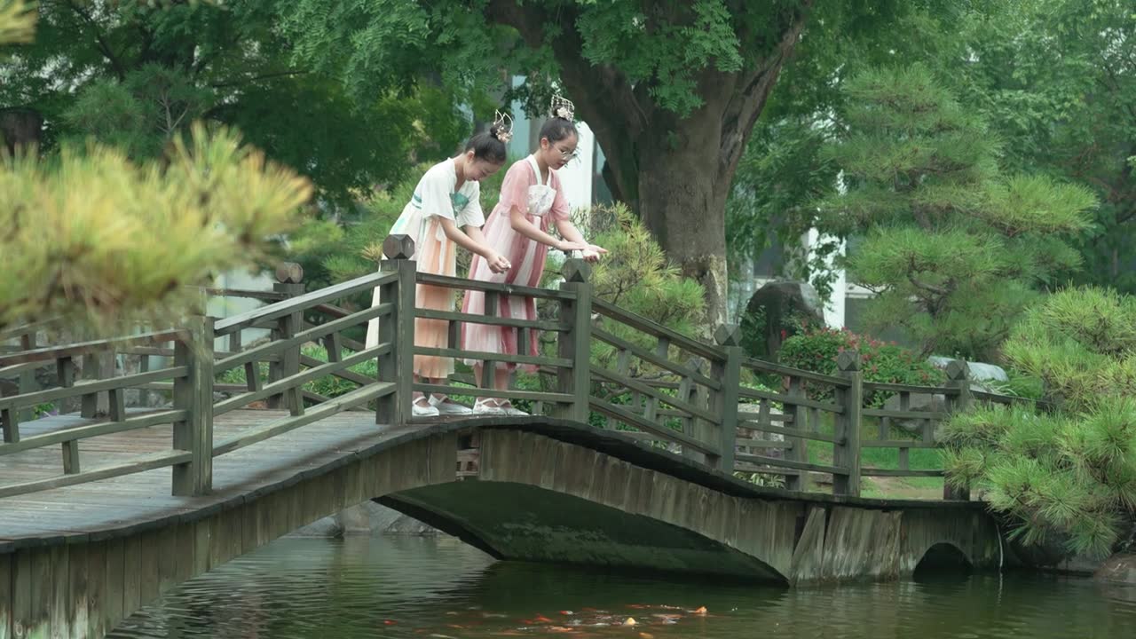 详情图-女孩们穿着汉服，在公园喂锦鲤。