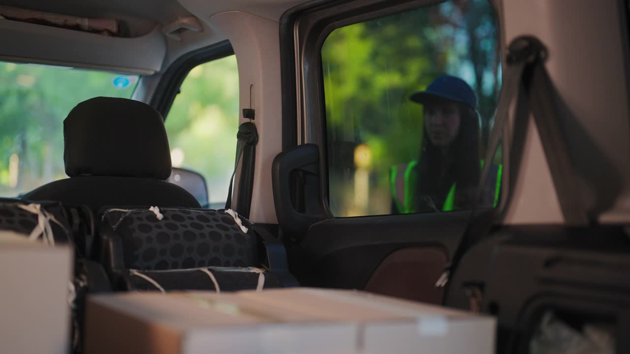 女快递员在给客户送快递前给纸箱上的条形码拍照