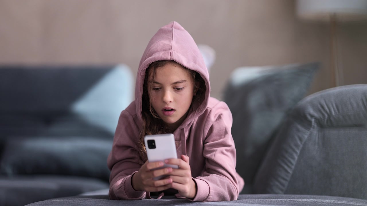 详情图-愤怒的少女用她的智能手机。