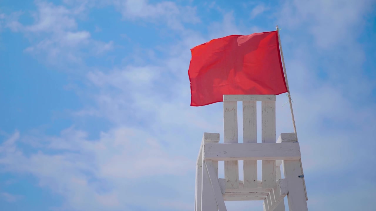 詳情圖-空的白色木制救援椅在海灘上揮舞著紅旗