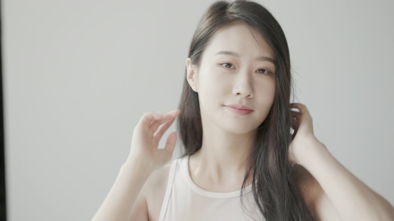 詳情圖-美麗的年輕亞洲女人與長長的黑色頭發(fā)，看著鏡子和拍攝慢動(dòng)作在一個(gè)明亮的房間