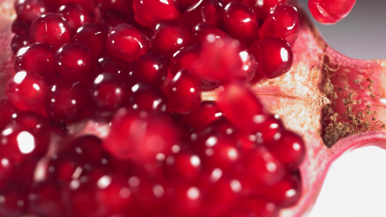 详情图-石榴颗粒在破碎的石榴表面以慢动作滚动