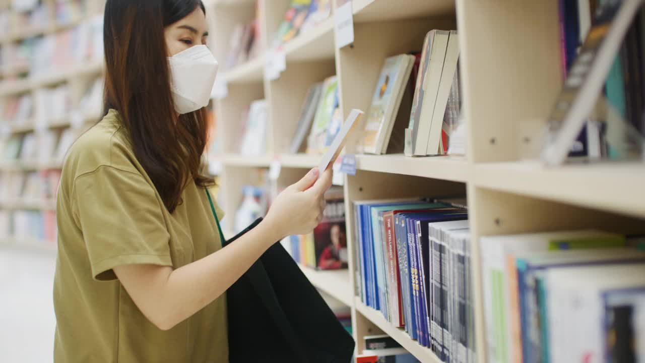 亚洲大学生在图书馆学习观察社交距离