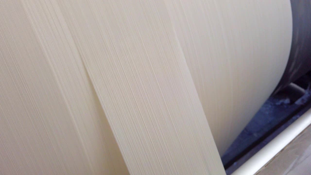 纺织厂工业整经机上按顺序排列的白色线轴、筒管、线筒