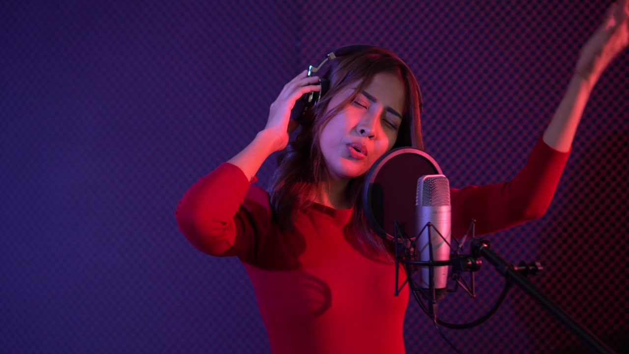 详情图-一位美丽的亚洲女歌手正在录音室练习唱歌。