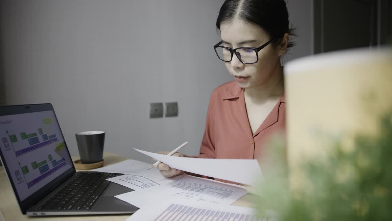 商务人员在办公室工作，分析财务总预算和使用笔记本电脑