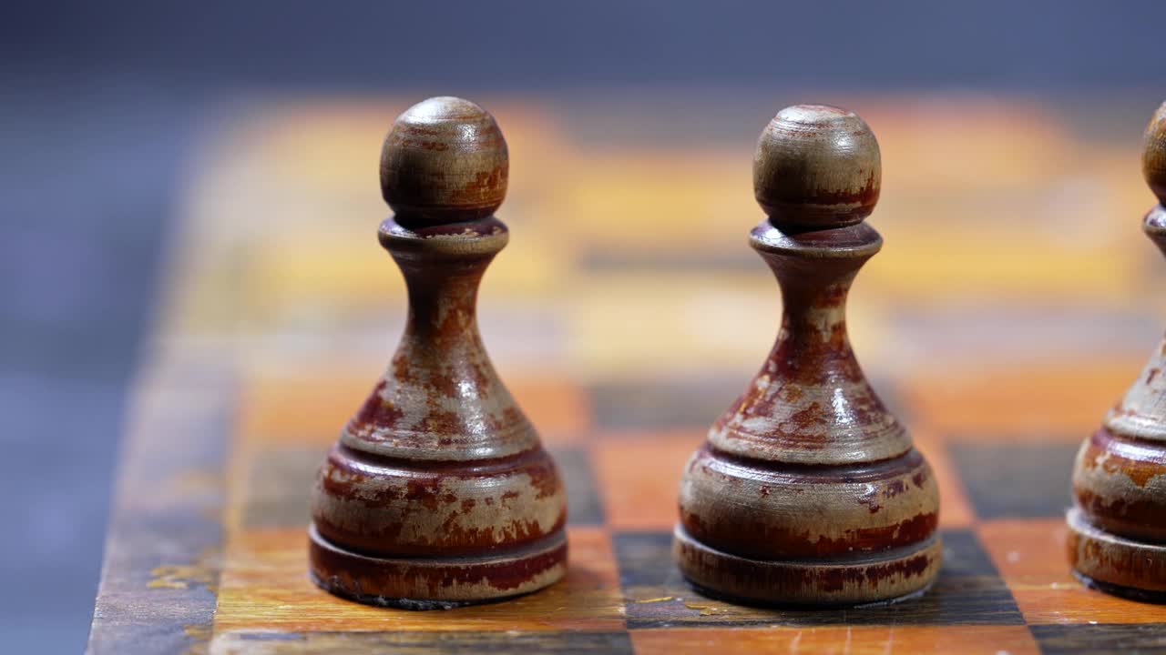 古老的棋盘上的棋子。董事会战略游戏。专注于站在一排衣衫褴褛的白色人物。团队合作，成功经营，智慧运动理念。