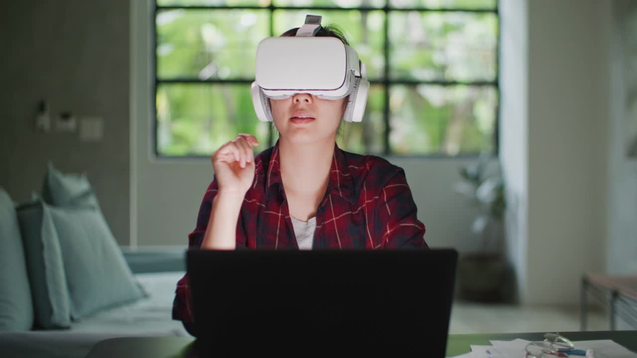 亚洲女性使用VR眼镜在家工作