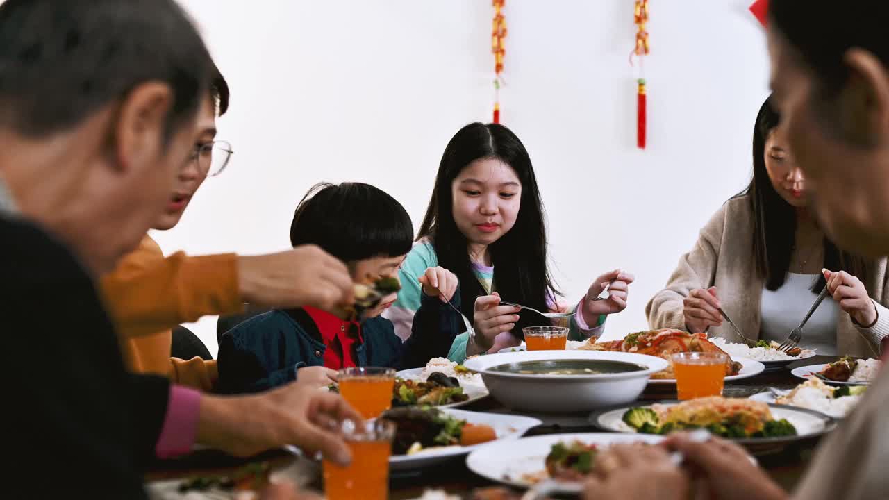 中国农历新年，欢乐的亚洲一家三口欢聚一堂，共进年夜饭